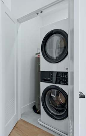 A washing machine is built into a wall in a room.
