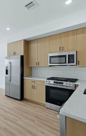 A kitchen with wooden cabinets and stainless steel appliances.