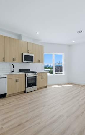 A kitchen with wooden floors and white walls.