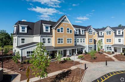A row of new houses with a clear blue sky above them.