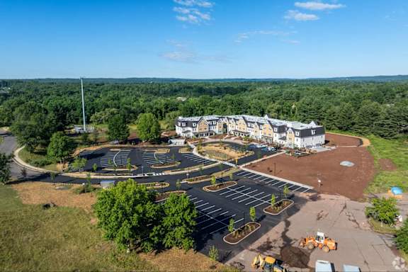 A construction site is in the foreground of a large building complex.