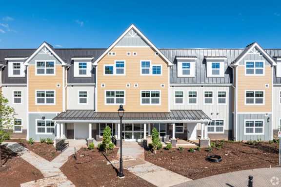 A large, modern building with a mix of beige and white colors.