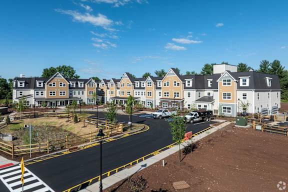 A row of houses with a street in front of them.