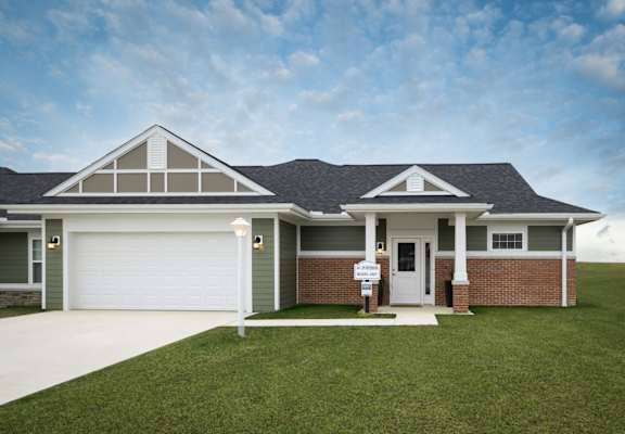 A house with a white garage door and a brick facade.