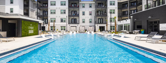 a swimming pool with an apartment building in the background