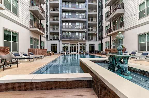 A large indoor pool with a fountain in the middle of it.