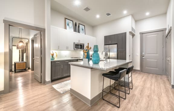 an open kitchen with a large island with bar stools