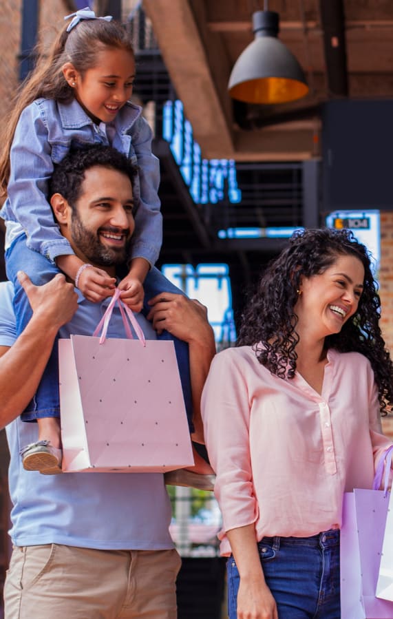 a family walking out of a store with shopping bags