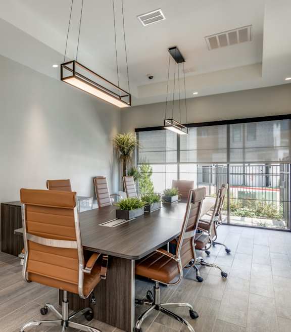 A conference room with a long table and chairs.