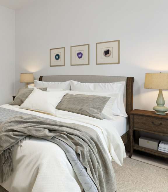 A bedroom with a bed, nightstand, and lamp.