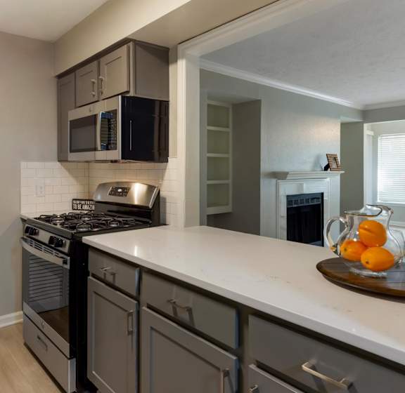 A kitchen with a stove top oven and a microwave above it.
