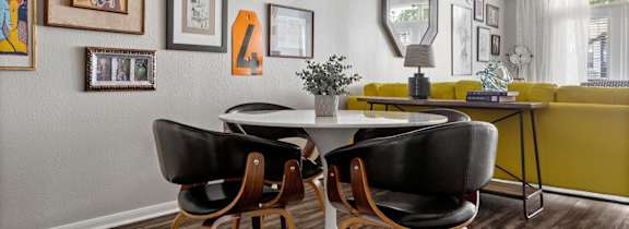 A dining room with a white table and chairs.