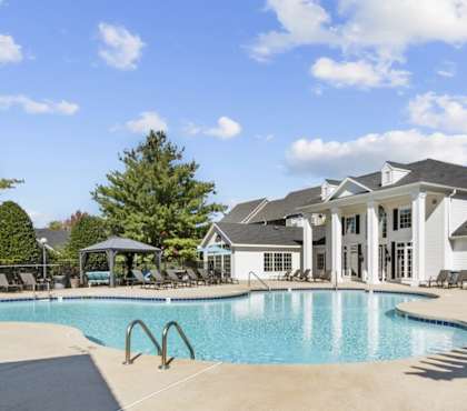 A large swimming pool in front of a house.
