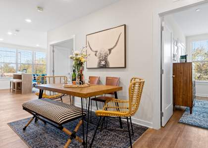 A dining room with a wooden table and chairs.