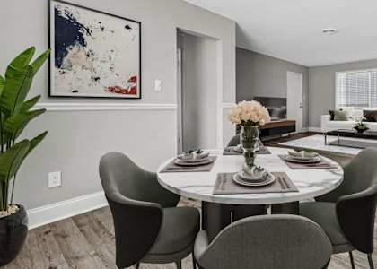 A dining room with a round table and chairs.