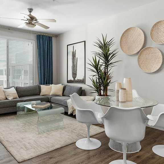 A living room at Skywater at Tempe Town Lake with a couch, TV, coffee table, and a dining room with a table and chairs. 