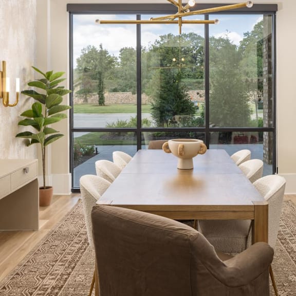 A modern dining room with a long table and chairs.