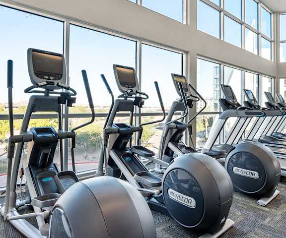 The cardio machines and large windows looking outside at Skywater at Tempe Town Lake Apartment Homes. 