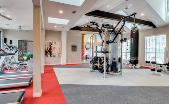 A gym with a red carpet and various exercise equipment.