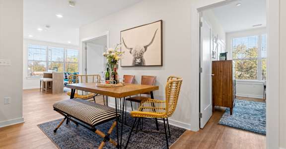 A dining room with a wooden table and chairs.