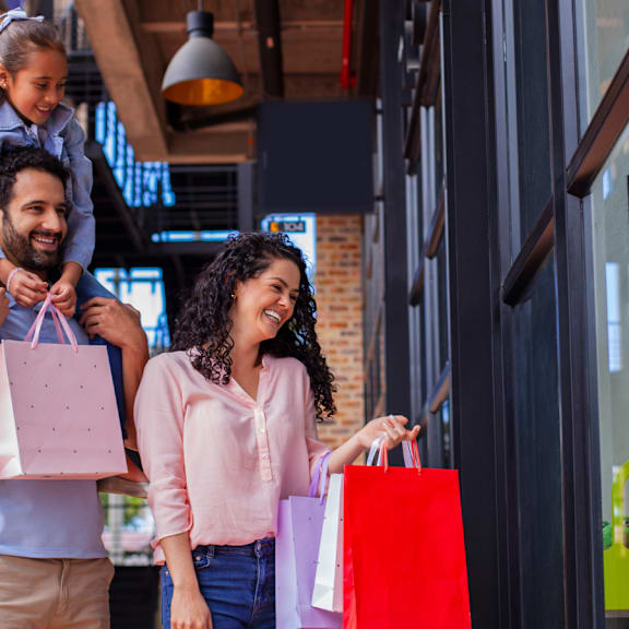 A family of three, a man, a woman and a child, are shopping together.