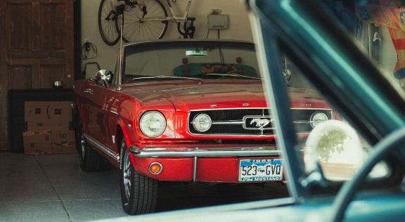 Red convertible parked in a private garage.