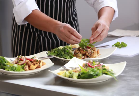 a chef prepares plates of food