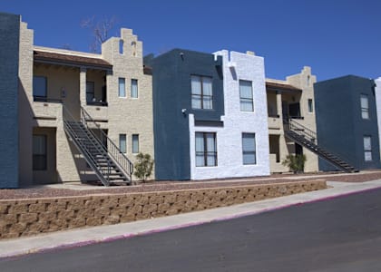 a row of apartment buildings on the side of a street