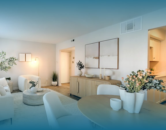 A modern living room with a white sofa, a white coffee table, and a white chair.