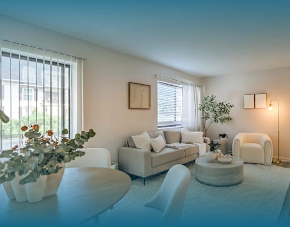 A modern living room with a white sofa, a white coffee table, and a white chair.