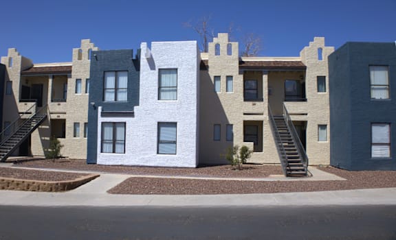 A row of modern houses with staircases leading to the front doors.