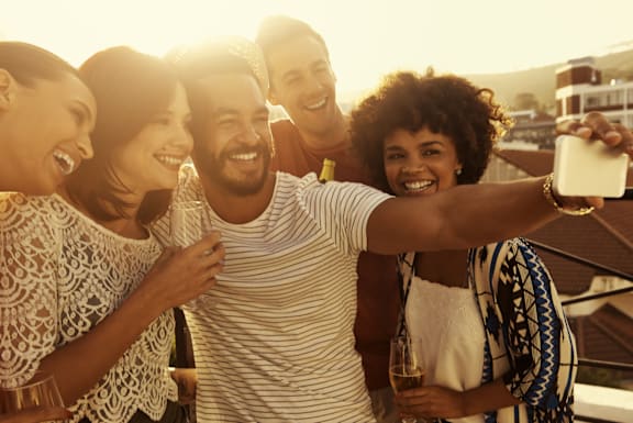 a group of friends taking a picture of themselves with a cell phone