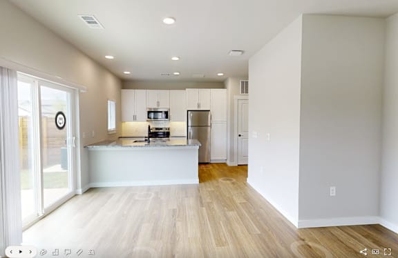 A kitchen with a white countertop and wooden flooring.