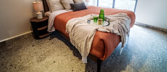 a bedroom with a bed and a bottle of wine on it
