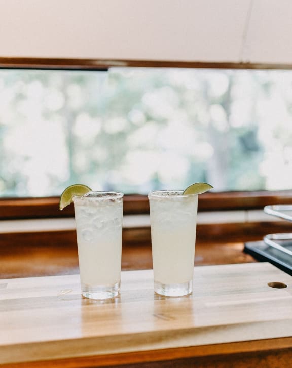 two cocktails on a table in front of a window