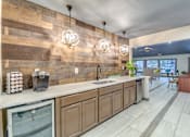 Thumbnail 19 of 27 - Coffee bar with spherical pendant lighting and wood accent wall at The Colony Apartments, Universal City, TX 78148