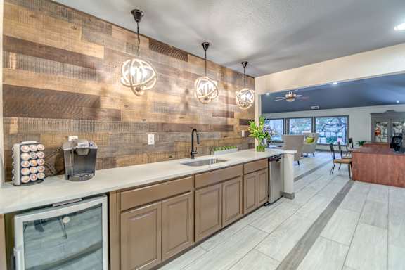 Coffee bar with spherical pendant lighting and wood accent wall at The Colony Apartments, Universal City, TX 78148
