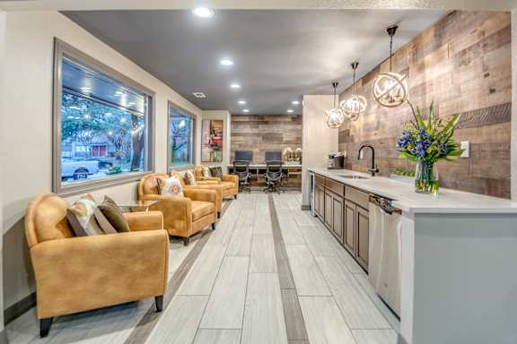 Resident lounge with kitchenette and decorative pendant lights at The Colony Apartments, Universal City, TX