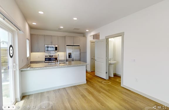 A kitchen with a refrigerator, microwave, and oven.