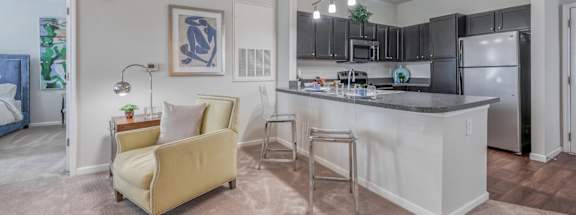 A kitchen with a white island and a yellow couch.