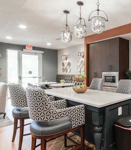 a kitchen with a large island and chairs at Haven at Congaree Pointe 55+ Apartments, Columbia, 29209