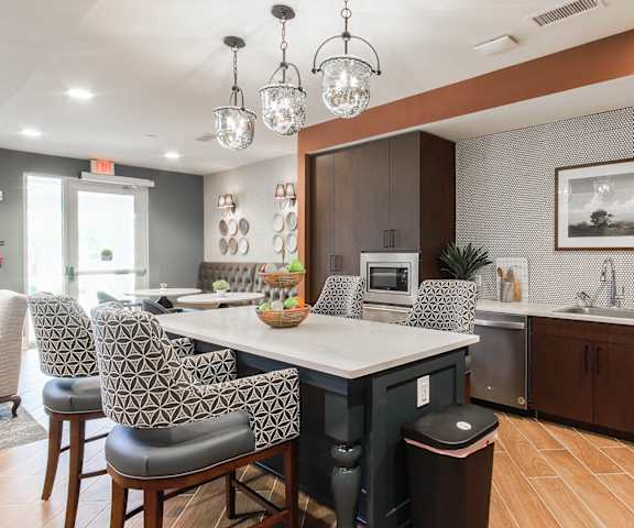 a kitchen with a large island and chairs at Haven at Congaree Pointe 55+ Apartments, Columbia, 29209