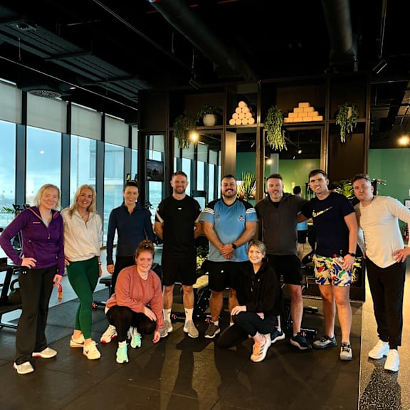 A group of people posing for a photo in a gym.