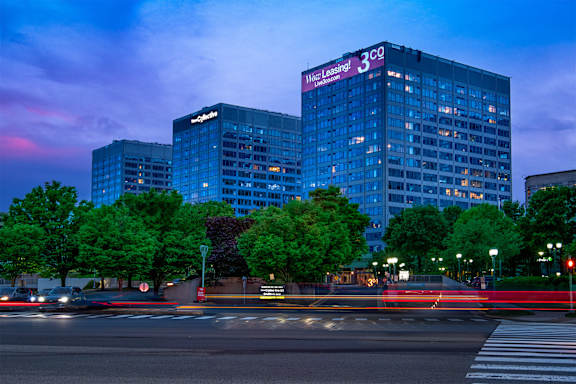 A cityscape at dusk with a large building that has a sign that says "Mace Leasing 3".