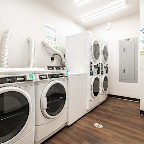 A row of washing machines with the number 35 on the front of the second one from the right.