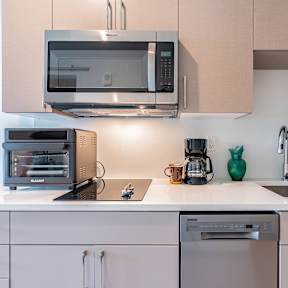 A modern kitchen with a stainless steel oven and cabinets.