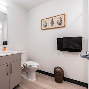 A bathroom with a toilet, sink, and towels.