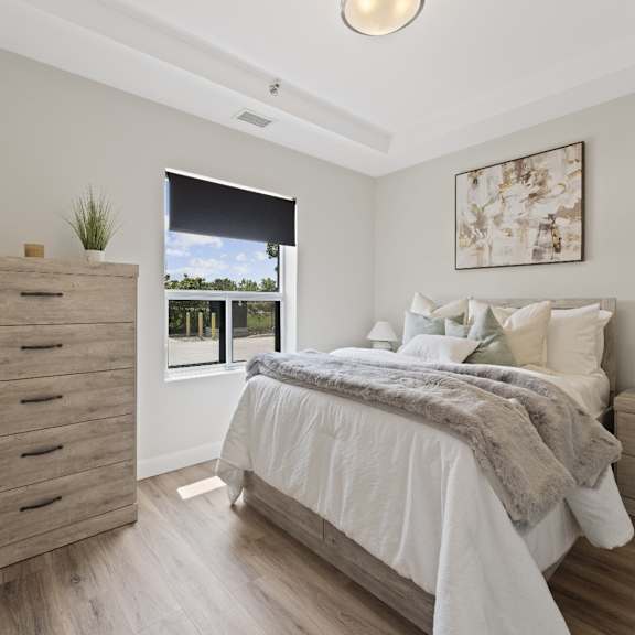 a bedroom with a bed, two nightstands, and a bench