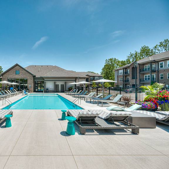 A sunny day at the pool with lounge chairs and umbrellas.