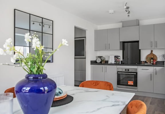 a kitchen or kitchenette with a table and a vase of flowers
